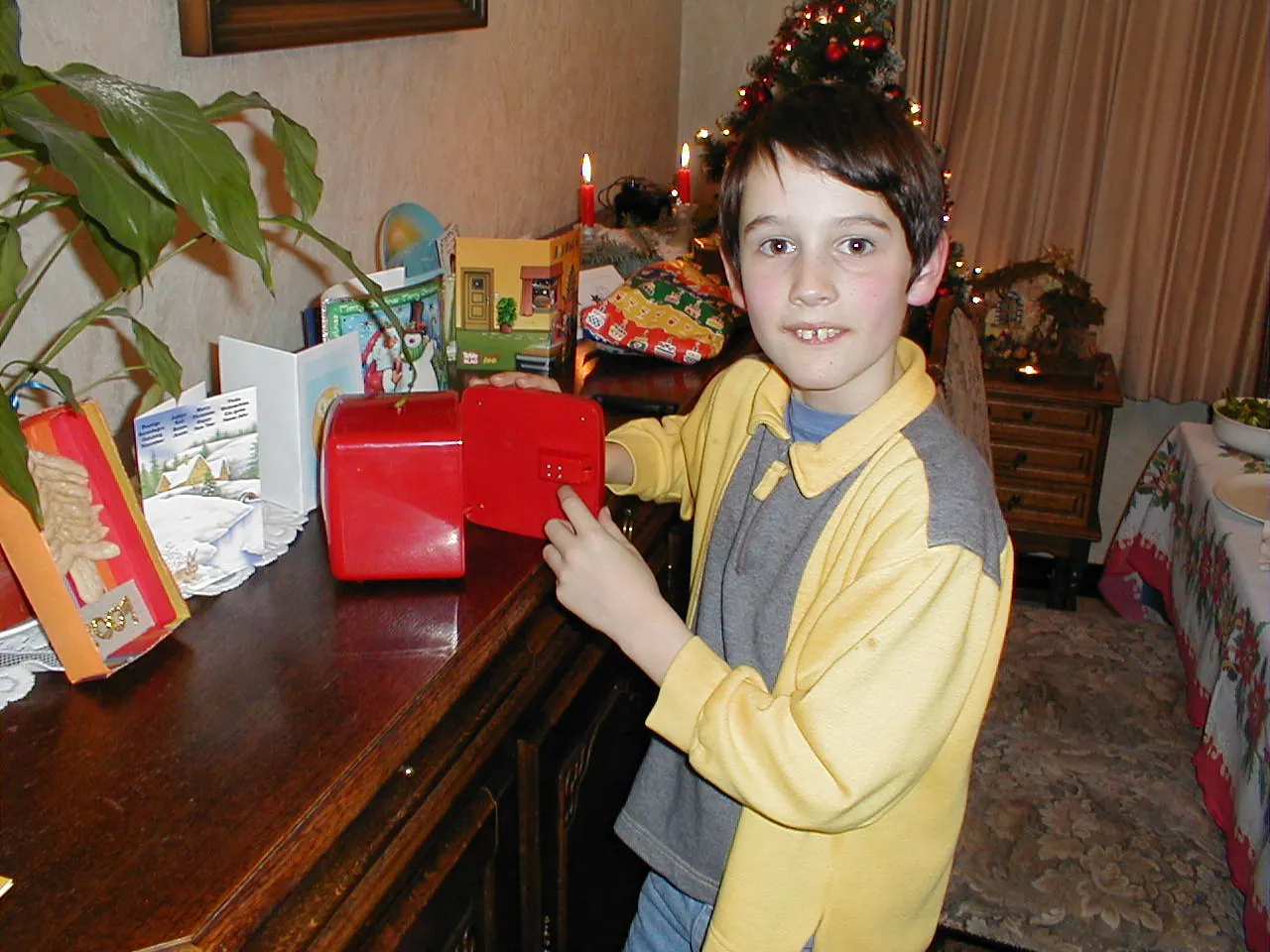 Jurgen als kind bij de kerstboom met een rood kluisje in zijn handen