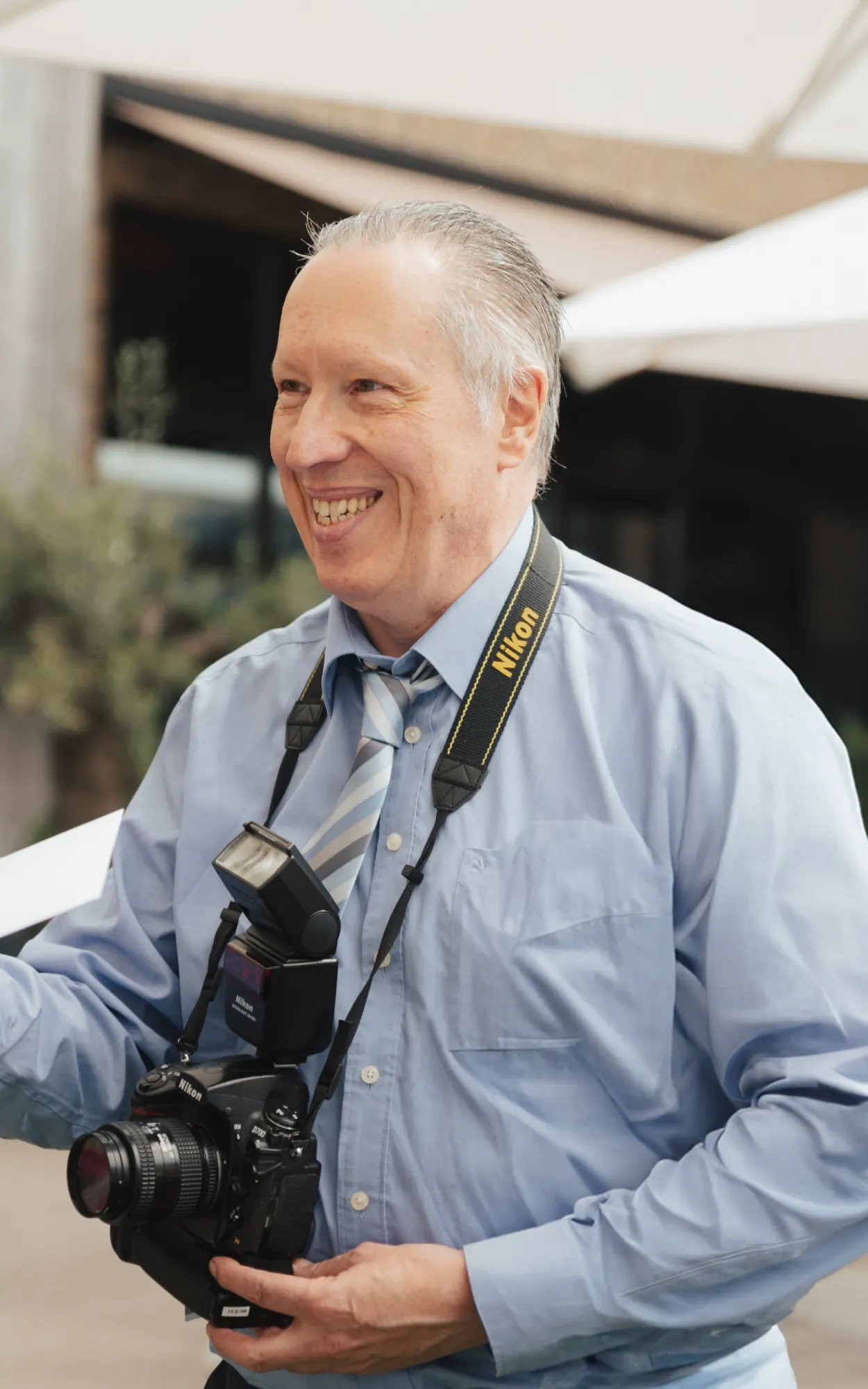 Johan Lenaert lacht met zijn Nikon om de hals, op de trouw van Jurgen