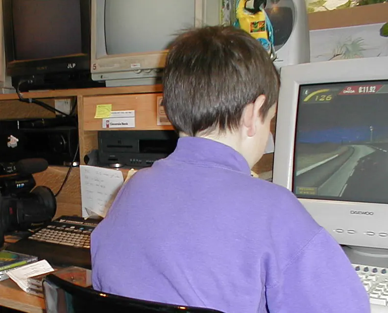 Jurgen als kind aan de computer op de zolder van zijn vader, tussen de camera en de monitors van JLP